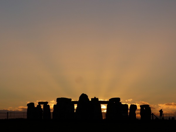 The sun sets behind Stonehenge in midwinter